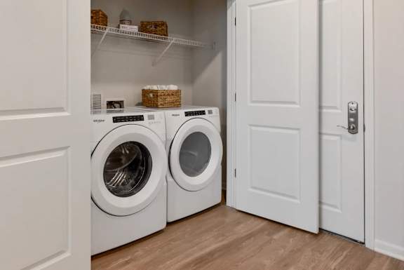 Two washing machines are in a white cabinet.