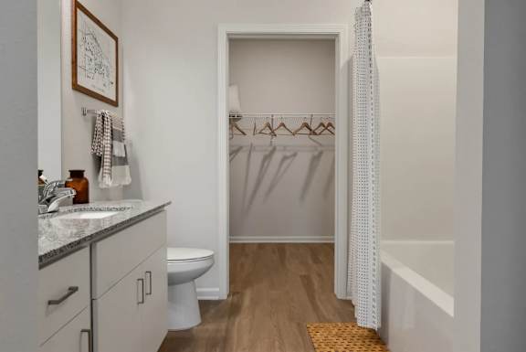A bathroom with a toilet, sink, and a shower with a white curtain.