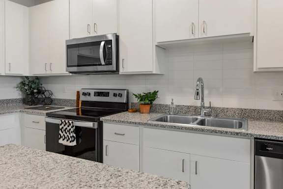 A modern kitchen with granite countertops and stainless steel appliances.