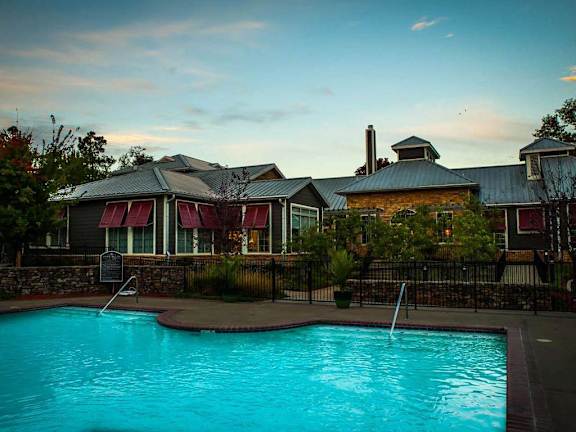A pool in front of a building with a sign.
