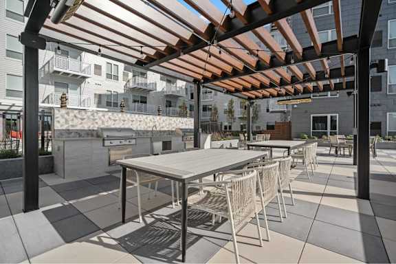 A patio with a table and chairs under a pergola.