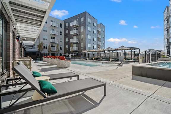 Pool with lounge chairs at The Hallon new apartments in Hopkins, MN