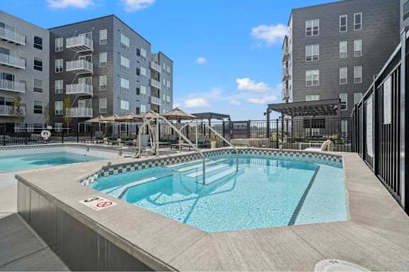 A swimming pool surrounded by apartment buildings.