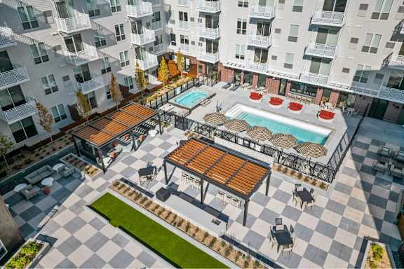 A large outdoor pool area with a hot tub and lounge chairs.