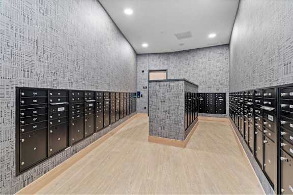 A long hallway with a patterned wall and wooden floors.