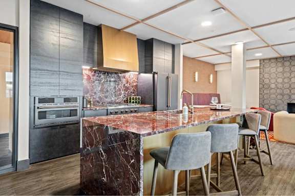 A kitchen with a marble countertop and modern appliances.