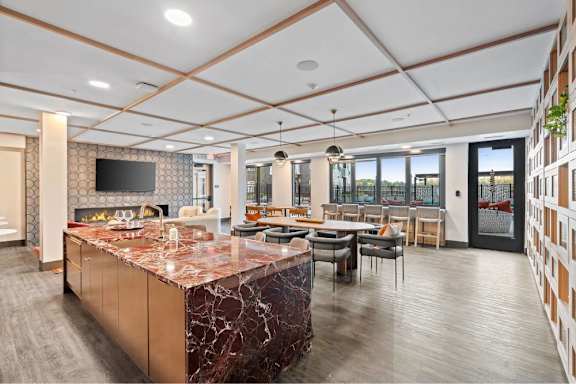 A kitchen with a marble countertop and a television mounted above it.