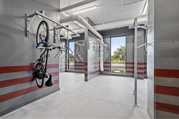 A bicycle is hanging on a bike rack in a room with striped walls.