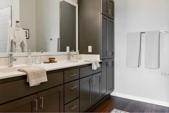 A bathroom with a double sink vanity and a large mirror.