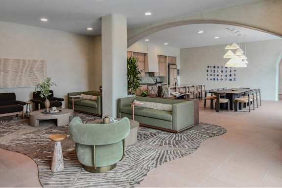 A living room with a green sofa and a patterned rug.