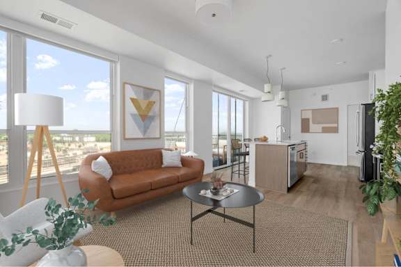 A living room with a brown couch and a grey table.