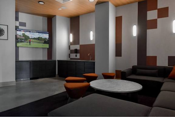 A modern lounge area with a television playing a sports game.