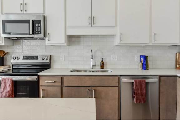 A kitchen with white cabinets and a black stove top oven.