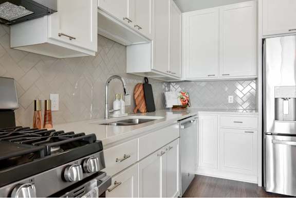 A kitchen with white cabinets and a black stove top.