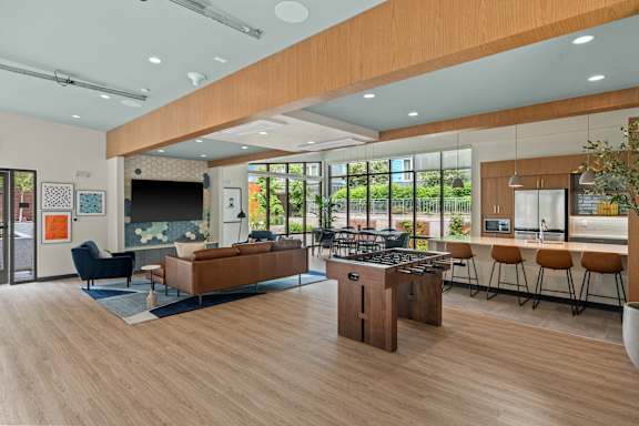 A modern living room with a fireplace and a kitchen area in the background.