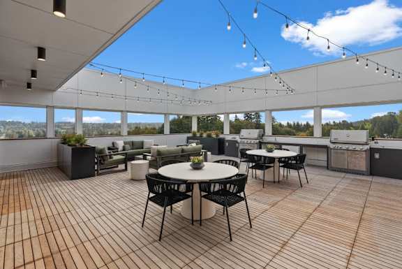 A patio with a table and chairs is set up on a wooden deck.