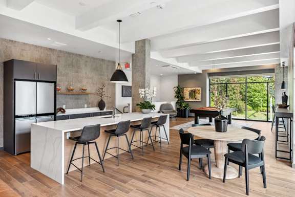 A modern kitchen with a bar area and dining table.