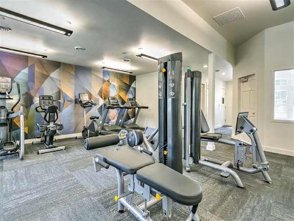 A gym with a variety of equipment including a leg press machine.