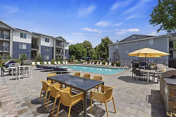 A poolside area with a table and chairs.