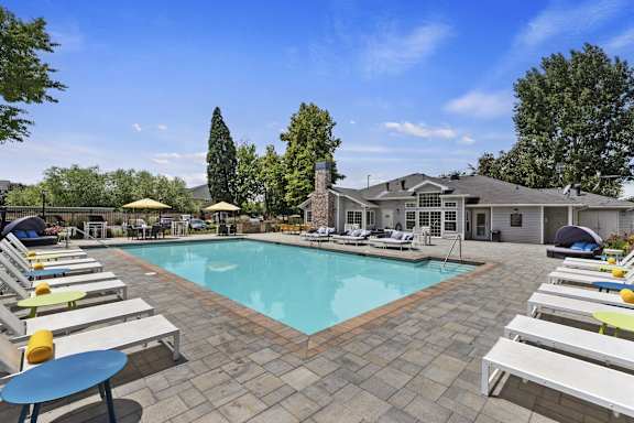 A pool surrounded by sun loungers and umbrellas.