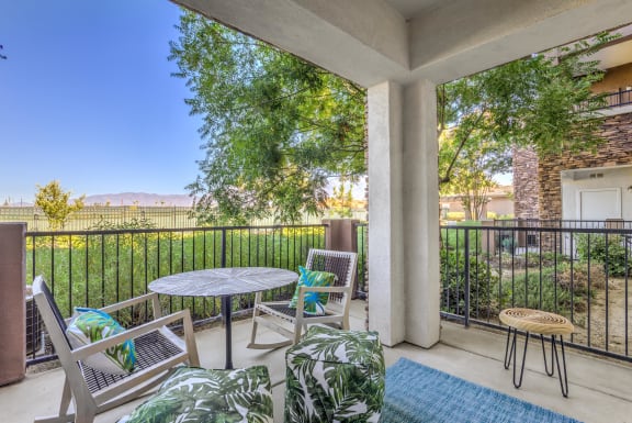 a patio with a table and chairs and a fence