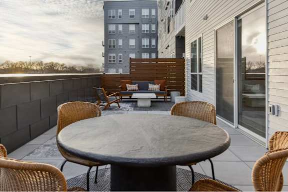 A patio with a table and chairs is set up on a balcony.