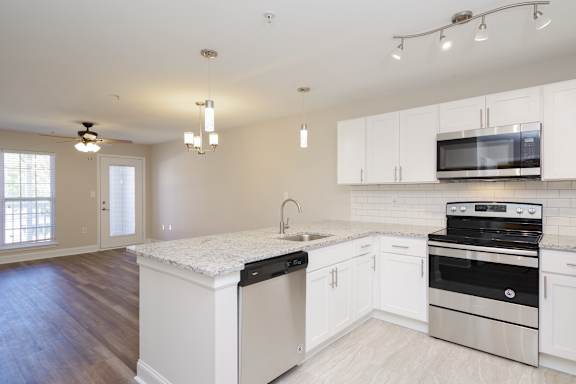 A kitchen with white cabinets and a black stove top oven.