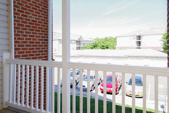 A white fence with a red car in the background.