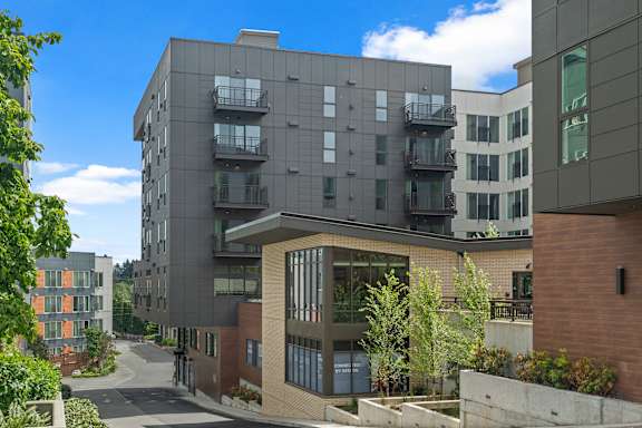 A modern apartment complex with balconies and a mix of brick and concrete buildings.