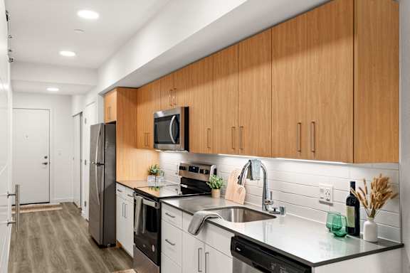 A modern kitchen with wooden cabinets and stainless steel appliances.