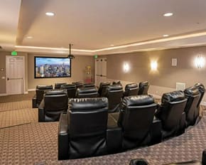 a room filled with leather chairs and a flat screen tv