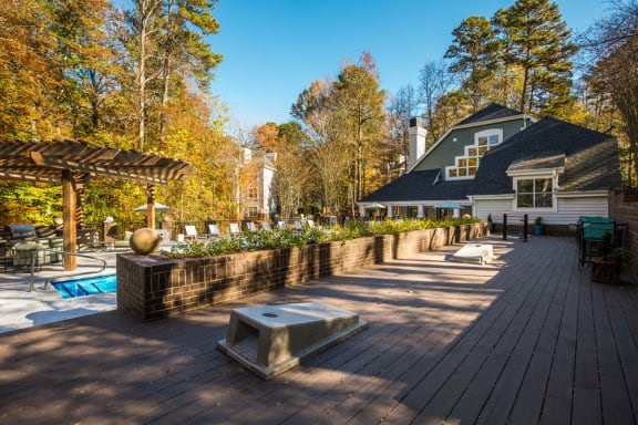 a large deck with a pool and a house in the background
