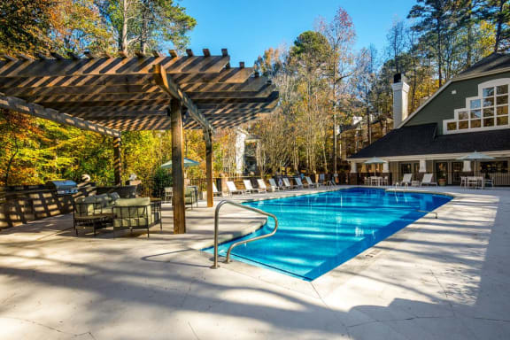 a swimming pool with chairs and umbrellas around it