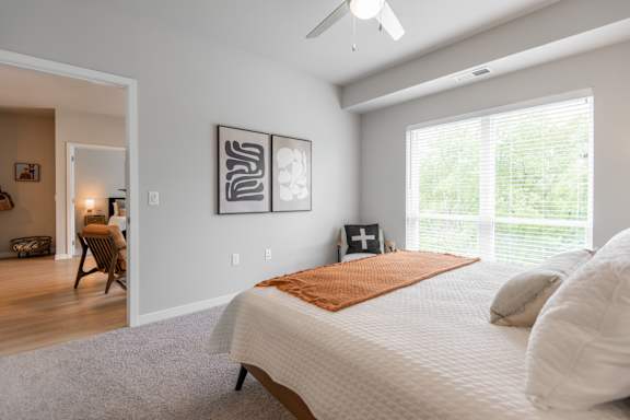 A bedroom with a large bed and a ceiling fan.