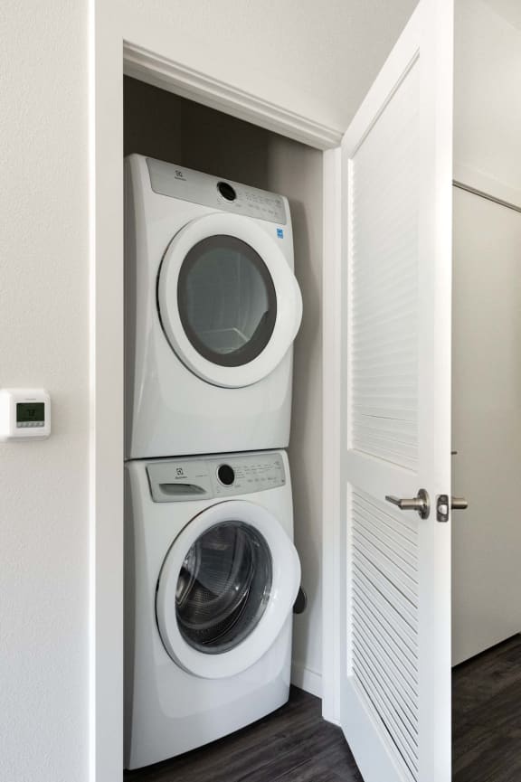 a washer and dryer in a small closet in a room with a door