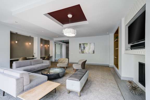 A modern living room with a grey sofa set and a fireplace.