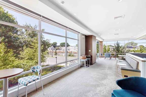 A sunny day in a spacious room with a view of the street and trees outside.