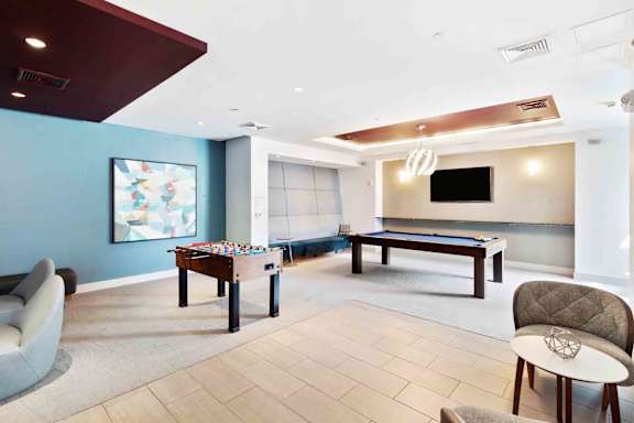 A room with a pool table and a couch.