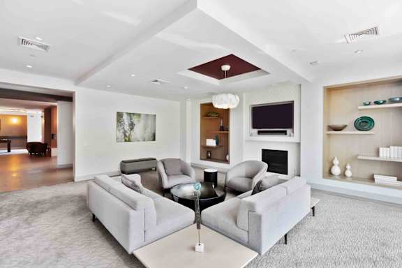 A living room with a grey couch and a fireplace.