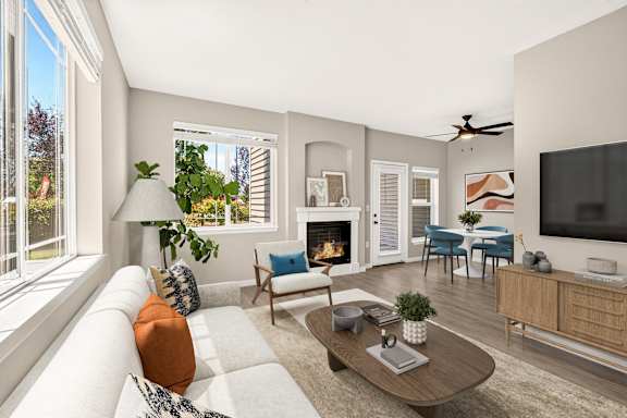 A living room with a fireplace, a couch, a chair, a coffee table, and a television.