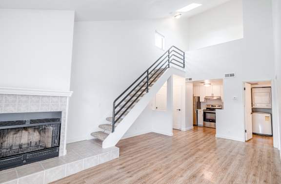 A modern open concept living space with a staircase leading to the upper level.