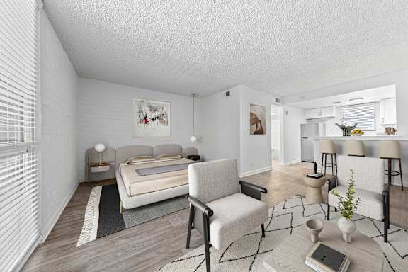 A bedroom with a bed, chair, and a table.