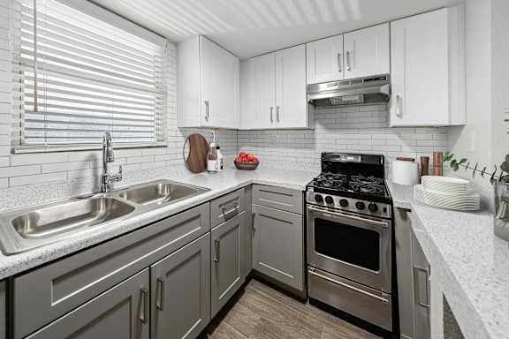A modern kitchen with a stainless steel oven and a white countertop.