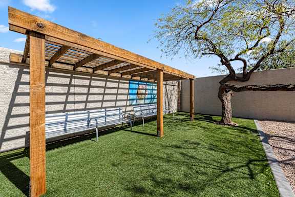A wooden pergola with a bench underneath it.