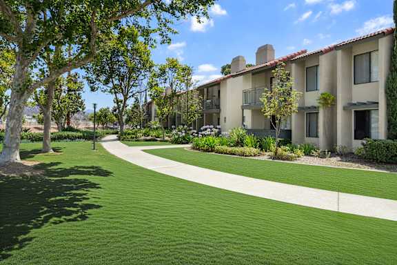 A grassy area in front of apartment buildings.