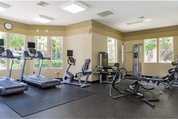 A gym with treadmills, elliptical machines, and other exercise equipment.
