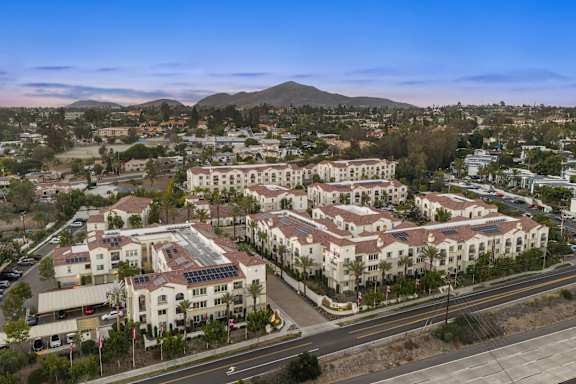 An ariel shot of SETA Apartments at dusk with a mountain in the background.