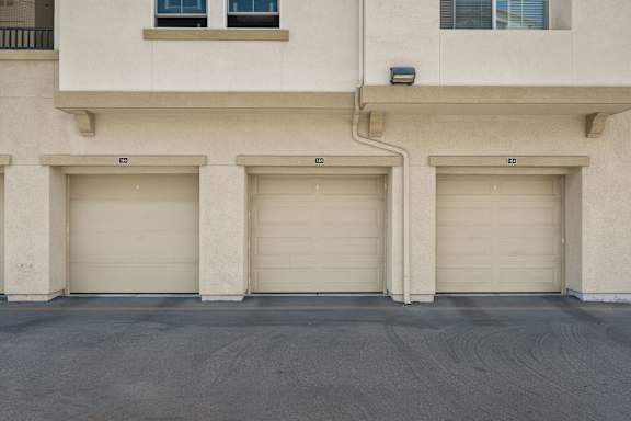 A row of beige townhouses with spacious private garages.