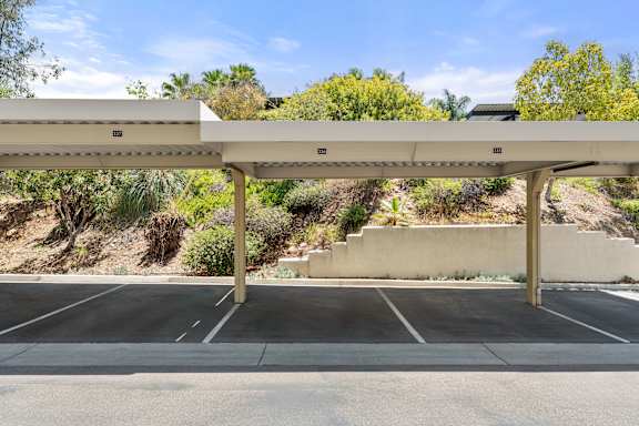 Parking spots with a white canopy overhead.