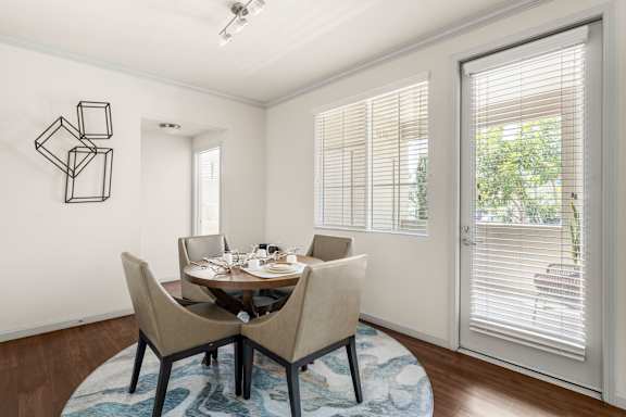 A dining room with a table set for two and a wall art.